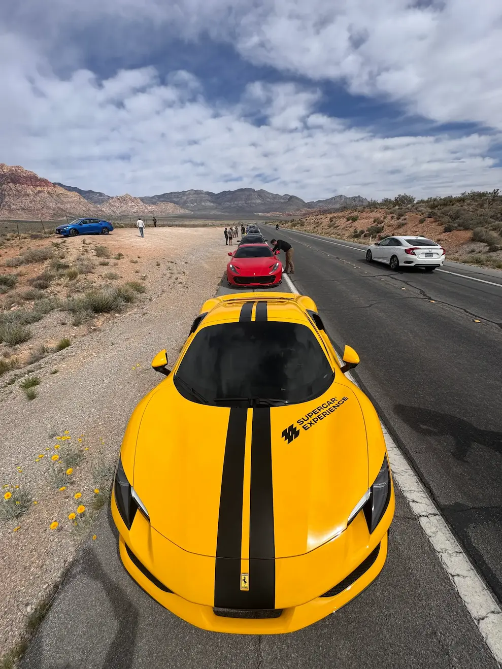 A convoy of exotic cars lined up on a desert road outside Las Vegas