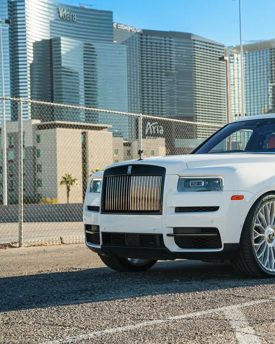 White Rolls-Royce Cullinan Black Badge rental in front of the Las Vegas skyline